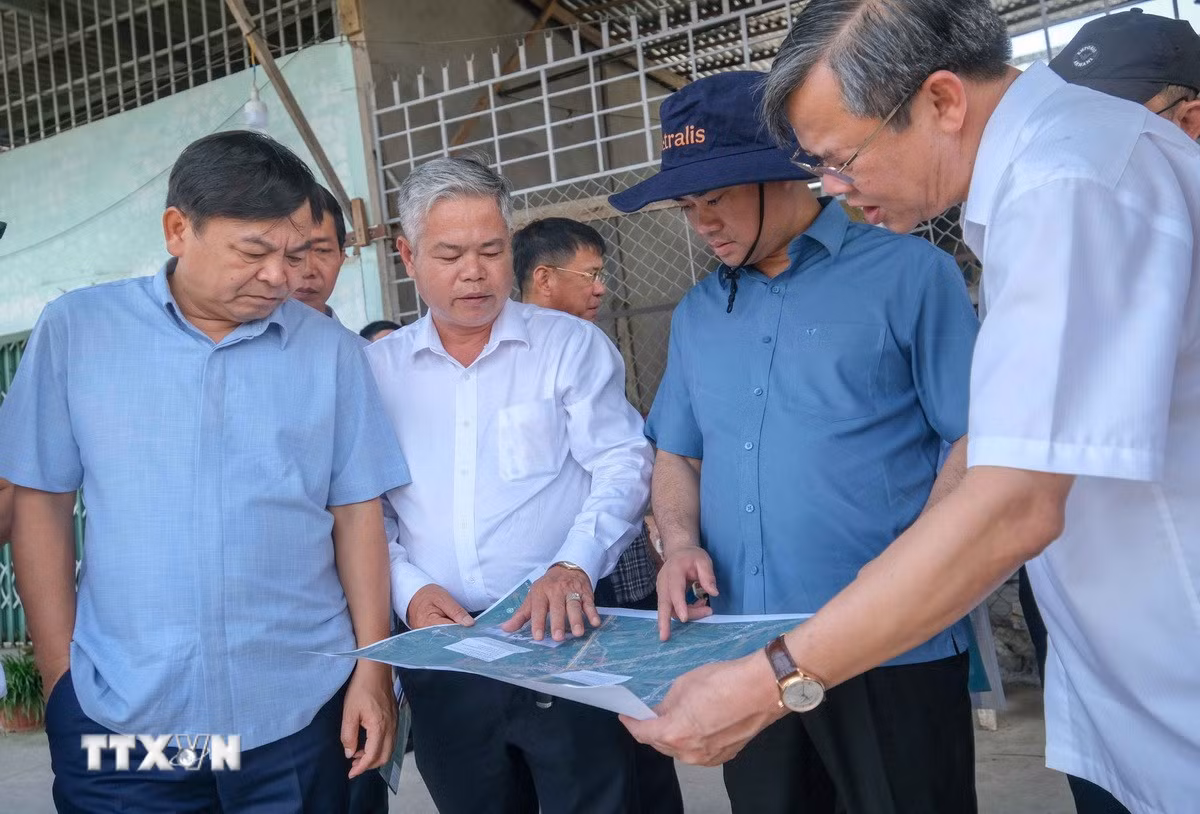 Bộ trưởng Bộ Nông nghiệp và Môi trường Trịnh Việt Hùng (thứ 2, bên phải) xem bản đồ vị trí sát lở trên kênh Nàng Mau, xã Thạnh Hòa, thành phố Cần Thơ. (Ảnh: Thanh Liêm/TTXVN)